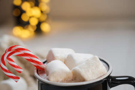 Close up Cocoa with marshmallows and chocolate on a background of Christmas lightsの写真素材