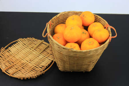 A bunch of mandarin oranges in rattan basketの写真素材