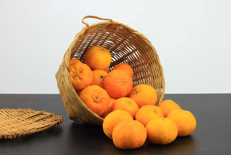 A bunch of mandarin oranges in rattan basket
