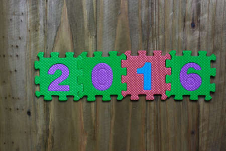 Letter puzzle block and number 2016 with wood backgroundの写真素材