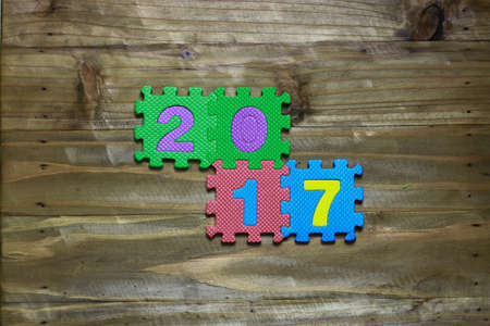 Letter puzzle block and number 2017 with wood backgroundの写真素材