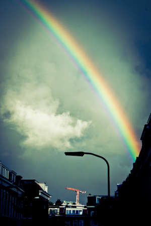 Bright rainbow above houses   buildings in the city of Haarlemの写真素材