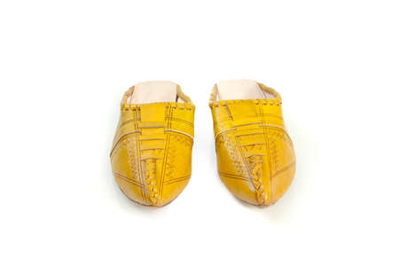 A tiny pair of delicate, intricately detailed green slippers from Morocco, isolated on white  Shallow depth of field--focused on front shoe の写真素材