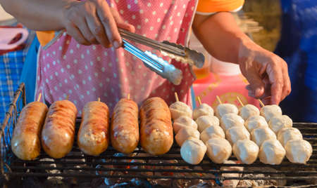 thai street food sausages and meatballs on grillの写真素材