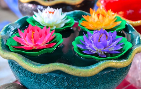 colorful artificial plastic lotus flower floating in a bowlの写真素材