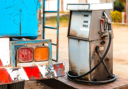 old dirty gas station pump with fuel truckの写真素材