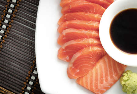 top view shot of japanese food raw salmon red fish sashimi slices on a dish with sauceの写真素材