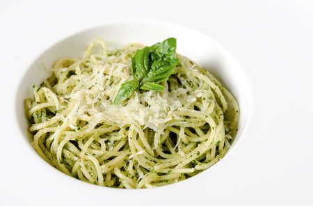 spaghetti pasta with pesto sauce on white plateの写真素材