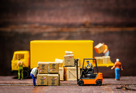 miniature warehouse workers forklift carrying goods box to semi truck with trailer .logistics warehouse freight transportation conceptの写真素材