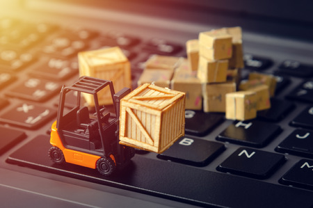 forklift freight car truck loading goods product wooden boxes and parcel on laptop computer keyboard...