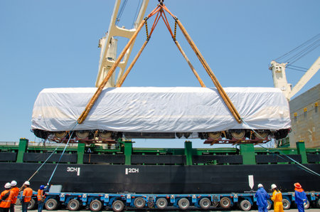 Unloading operation of project  cargo with port heavy lift cranes A crane on a large cargo ship docks loading a new diesel-electric locomotive.  at Laem Chabang Portの写真素材