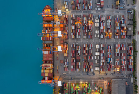 Top view Logistics and transportation of Container Cargo ship and Cargo plane with working crane bridge in shipyard at sunrise, logistic import export and transport industry backgroundの写真素材