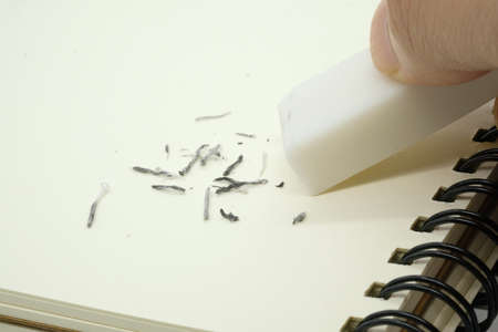eraser removing a written mistake on a piece of paper.の写真素材