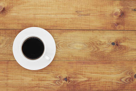 Coffee cup on wooden background top viewの写真素材