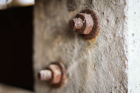 The rusty bolts on a cement pillar for vintage home background or texture.の写真素材