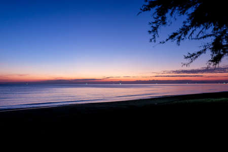 Sunset at sea with trees sway at Chaolao Tosang Beach Chanthaburi Thailand for background or texture.の写真素材
