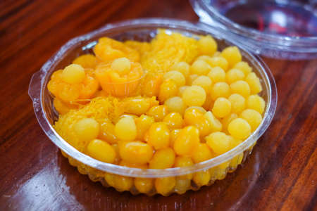 Dessert set consists of golden drops (egg yoke fudge balls cooked in syrup / thong yot), bean-paste, golden threads (foi thong), golden flowers (thong yip) in clear box - Thailand dessert concept.の写真素材