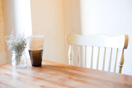 The beautiful houseplant with clear flowerpot and tissue in black box set on brown wooden table and white chair, for food or home background or texture - interiors concept.の写真素材