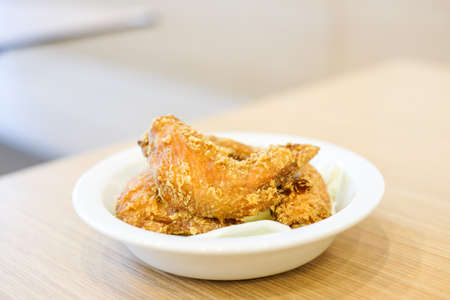 Delicious crispy fried chicken wings with green cabbage for snack serve on white plate for food background or texture - homemade concept.の写真素材