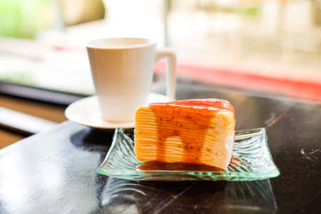 Part of crepe cake topped with strawberry sauce serve on clear dish and hot fresh milk in glass for dessert homemade background or texture - healthy diet concept.の写真素材