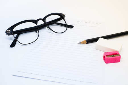 Black glasses, white paper, pencil, pink sharpener and eraser (rubber) for write your note - concept relax.の写真素材