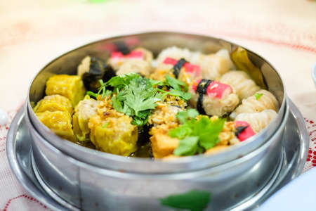 Mixed chinese steamed dumpling (dim sum), crab stick, ha gow, seaweed, coriander and garlic for background or texture - food chinese concept.の写真素材