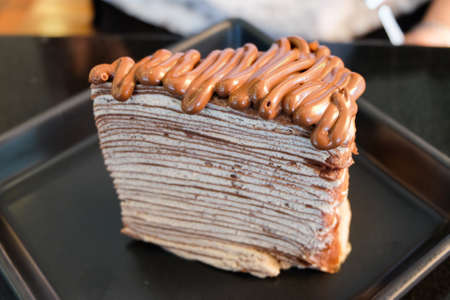 The crepe cake topped with chocolate sauce serve on black dish for dessert homemade background or texture.の写真素材