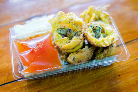 Mussels in Takoyaki balls serve on plastic box with sweet sauce - Japanese or Thai-style food background or texture.の写真素材