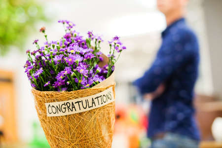 Beautiful violet or purple Gypsophila flower in brown grid paper bouquet for you with "Congratulations" word for wishing you all the best for your birthday or celebration concept.の写真素材