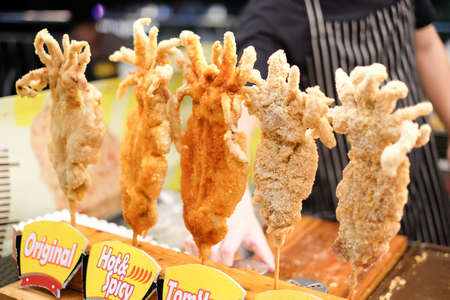 Bangkok, Thailand - May 12, 2018 : Crispy fried squid with barbecue powder or hot spicy, Tom-yum & original tasty - Taiwanese style fried snack at street food night market - Central Rama II.のeditorial素材