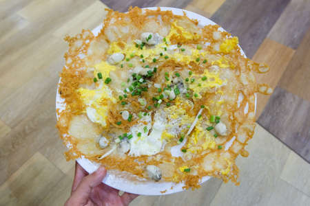 Oysters pan-fried crispy in egg batter (Hoi Tod) with bean sprout & spring onion serve on white...