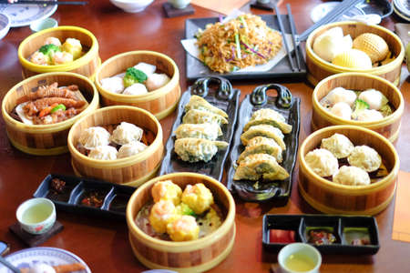 Mixed chinese steamed dumpling (dim sum), crab stick, ha gow, seaweed, coriander, noodle, gyoza and garlic for background or texture - food chinese concept.