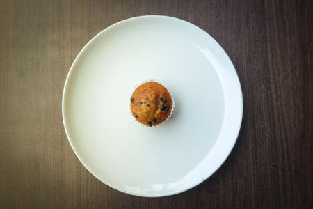 Muffin chocolate lava (banana cake) with chocolate chip, almond and banana smell on white plate for...