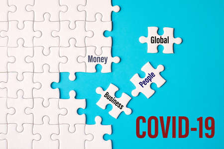 The global word, money word, people word, business word on white jigsaw puzzle on blue background - idea COVID-19 concept.の写真素材