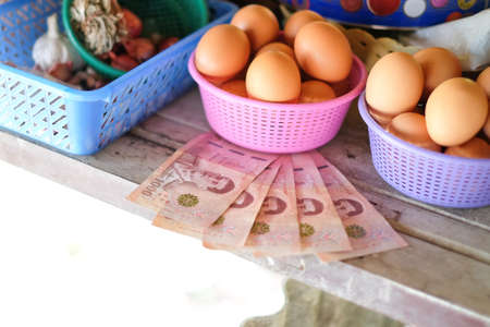 Thai money 5000 baht (government support people from coronavirus or COVID-19 situation) and food (vegetables, egg) - finance Thailand concept.の写真素材