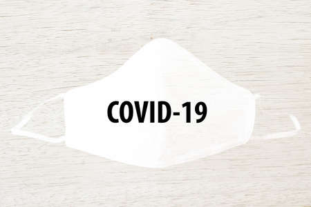 Cloth white mask isolated on modern white wooden background - for prevent dust (PM 2.5), disease (Coronavirus or COVID-19).の写真素材