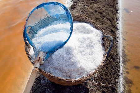 salt in the bamboo basket on the ground near salt pan, Thailand