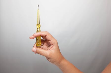 Hand holding screwdriver on whiteの写真素材