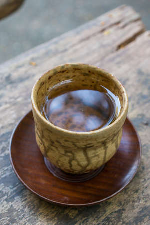 A cup of hot tea on the wood table.の写真素材