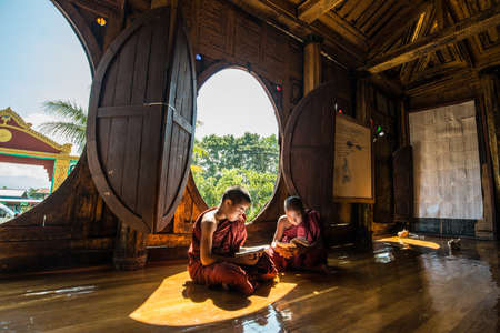 NYAUNGSHWE, MYANMAR - OCT 05 2014: Myanmar novice reading the book in the Shwe-Yaunghwe monastery the big window temple in Myanmar.のeditorial素材