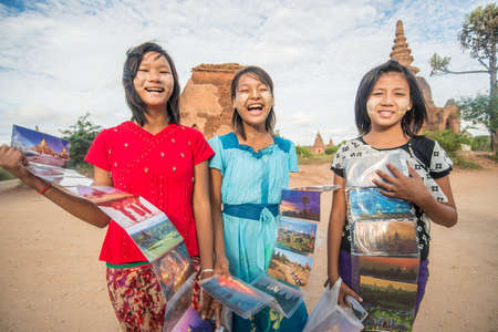 BAGAN, MYANMAR - OCT 11 2014: An unidentified girls sells postcard in old Bagan archaeology zone.のeditorial素材