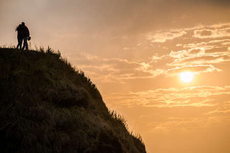 The couple standing on the top of mountain with romantic sunrise.