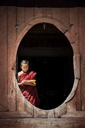 Myanmar novice reading the book in the Shwe-Yaunghwe monastery the big window temple in Myanmar.のeditorial素材