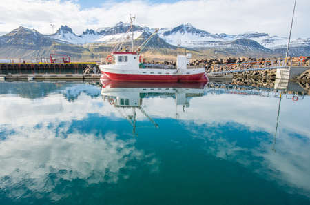 Small fishing ship parking at the Stodvarfjordur harbour a neat small town in East fjord of Iceland.の写真素材