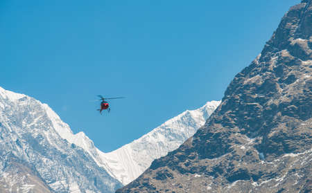Helicopter rescue flying over the snow mountains of Himalayas mountains range, Nepal.の写真素材