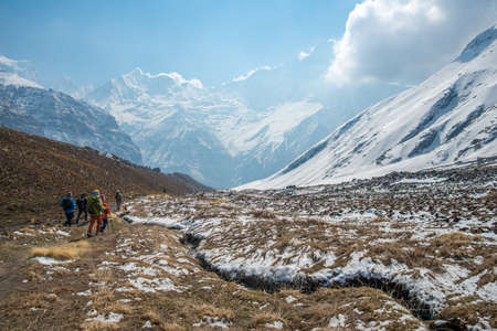 Tourist walking back from Annapurna base camp to foothills with the beautiful Machapuchare (Mt.Fish tail) mountain, Nepal.の写真素材