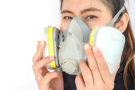 Portrait of young Asian woman wearing gas mask for protect smog bad air pollution or toxic. Air pollution has been associated with diseases of the heart and lungs, cancers and other health problems.の写真素材