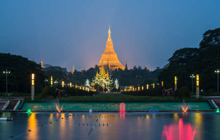 The Shwedagon pagoda with the colourful fountain view from people's park in Yangon township of Myanmar at night. It's Burmaâs most important Buddhist pilgrimage site.のeditorial素材
