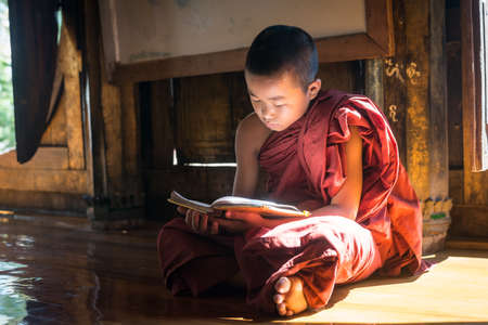 NYAUNGSHWE, MYANMAR - OCT 05 2014: Myanmar novice reading the book in the Shwe Yaunghwe Kyaung...