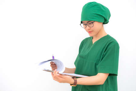 Portrait of young nurse woman wearing surgical gown with isolated white wall background when looking...